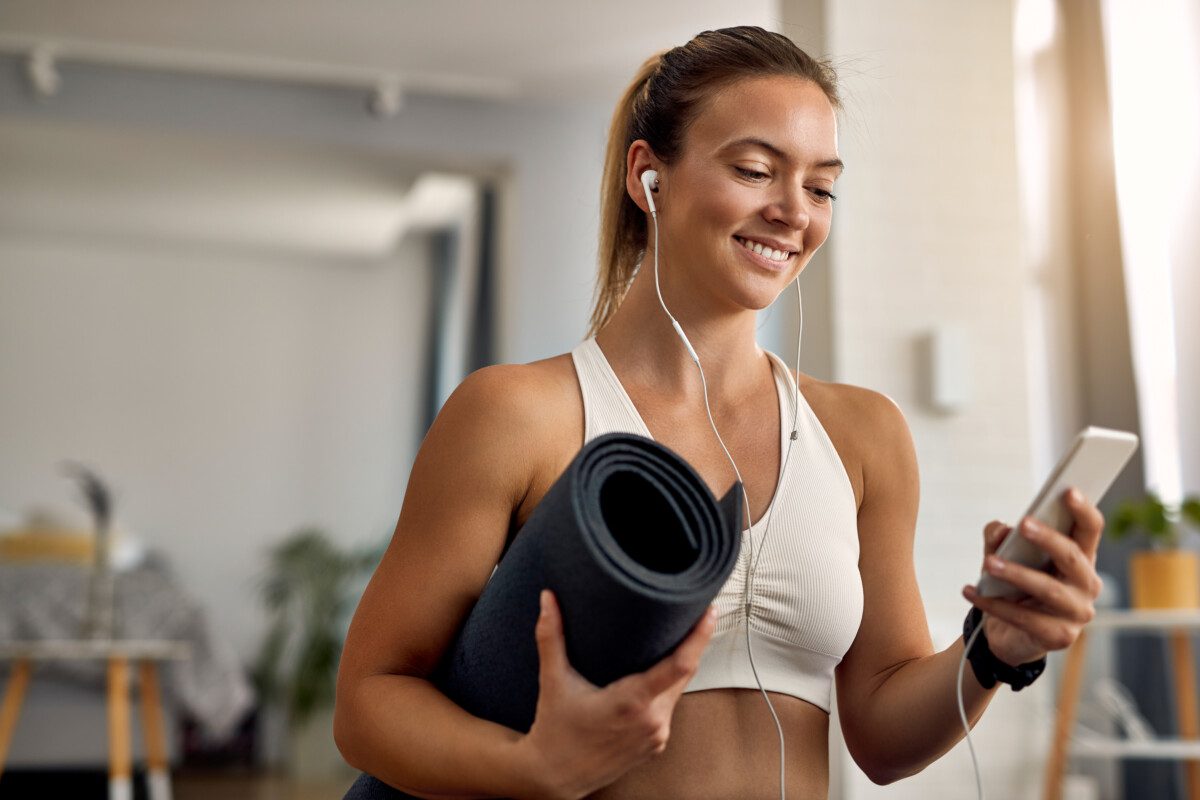 young-happy-athletic-woman-using-cell-phone-at-home